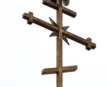 a bald eagle sitting on top of a cross