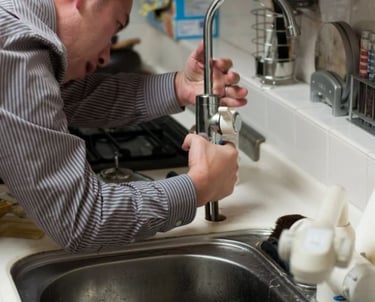 bc plumber a man in a shirt examining a tap
