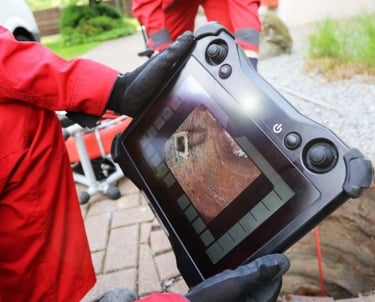 a person in a red suit and a camera bc plumber