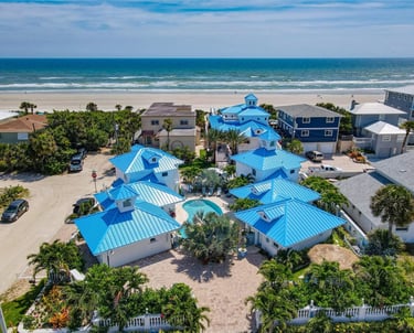 a beachfront home with blue roofing and blue roofing