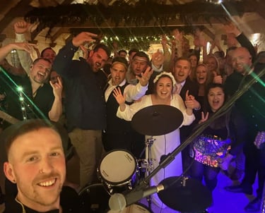 a group of people standing around a drum kit