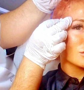 a woman with red hair and gloves on