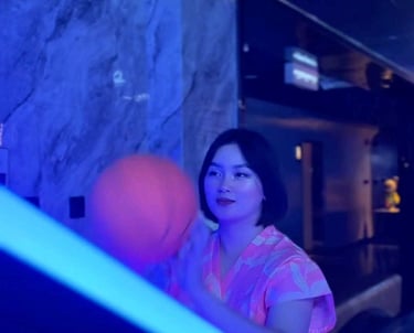 a woman in a pink dress playing with a ball