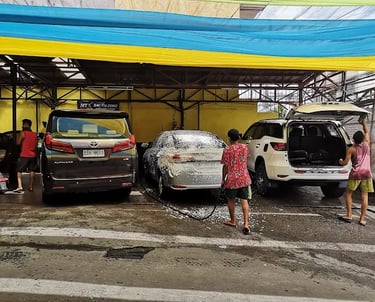 a man washing a car in a garage