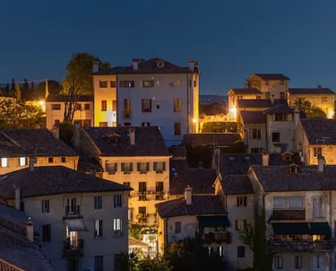 Evening view of a village in the Prosecco Hills, Veneto, with warm lights and historic rooftops