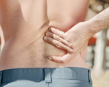 a man with a back pain holding his back