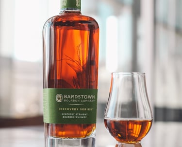 a bottle of bourbon whiskey in front of a glass of whiskey