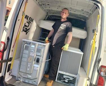 man stading next to washing machine in the back of van