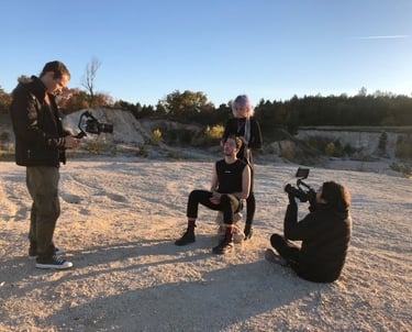 a man is filming a video of a man in a black shirt for youtube