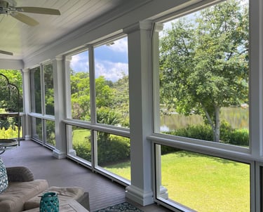 A beautiful screen porch with a couch and a table in James Island.