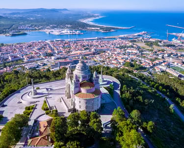 a large church with a steeple and a view of the ocean