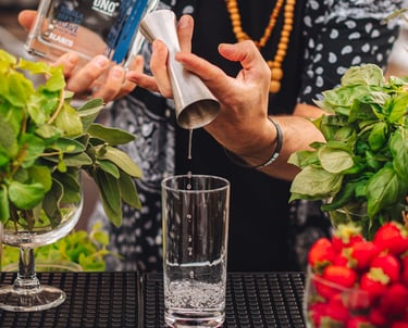 a man is pouring tequila into a glass with in the back a bottle of uno tequila blanco 