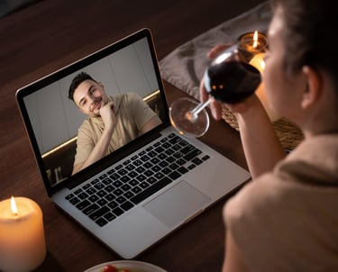 a woman is drinking wine while she is watching a video of herself