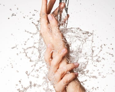 a person's hand holding a knife and a knife in the water