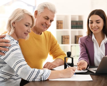 Professional mobile notary assisting couple with signing legal documents at their home.
