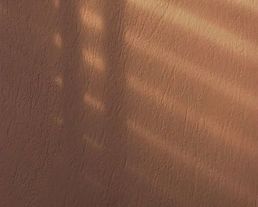 An orange walls with shadows of blinds being cast on the for LVF.LVX's shadow work website.