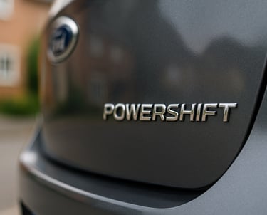Close-up do emblema “Powershift” na traseira de um Ford Focus estacionado em área residencial, com f