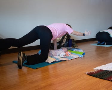 Mother in Spinal Balance yoga pose with Infant under her.
