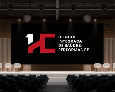 Auditório moderno com telão exibindo o logo HC e o texto “Clínica Integrada de Saúde & Performance”.
