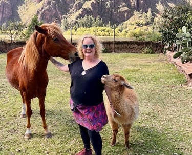 Sunni Dawson smiling with a horse and alpaca in mountains