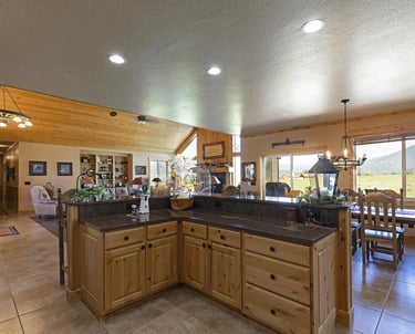 Victor MT custom house/home interior with kitchen island, wood cabinets, and granite countertop