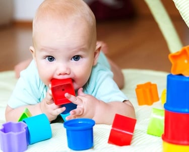 Un bebe mordiendo una pieza de plastico hecha de pigmentos de alta seguridad, libre de metales.