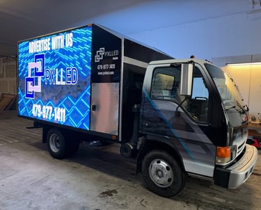 Mobile LED billboard truck by PXLLED parked in a garage for digital out-of-home advertising.
