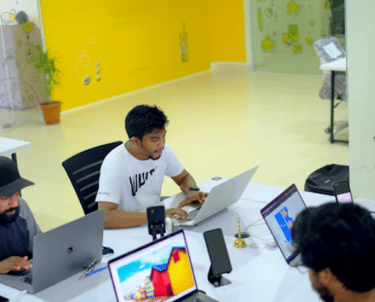 Équipe de développeurs et designers travaillant sur des projets web dans une agence digitale, entour