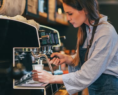 Femme debout devant une machine à café