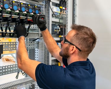  Homme en chemise bleue travaillant sur un cable d'alimentation