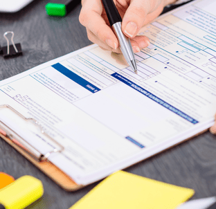 Personne remplissant un document sur une table