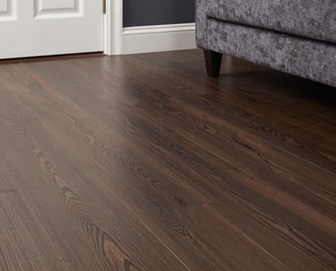 A craftsman installing sleek laminate flooring in a bright, modern room.