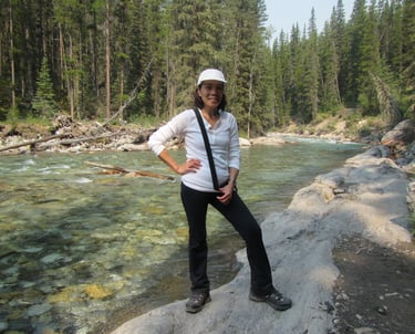 a person standing on a rock by the cascade river