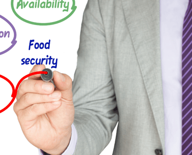 a man in a suit and tie is writing on a white board