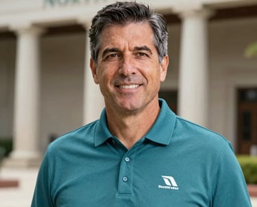 Professional portrait of a middle-aged sports executive in a teal polo shirt with a North American / Mexican architectural background. The lighting is soft and natural, conveying leadership and approachability.