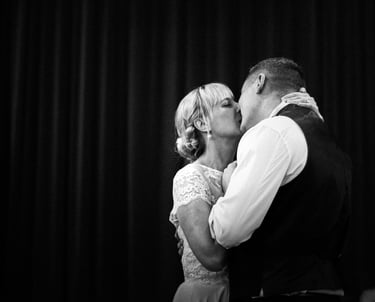 a bride and groom kissing in a black and white photo