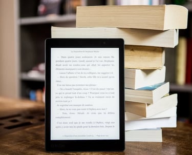 a tablet computer sitting on a table with a stack of books