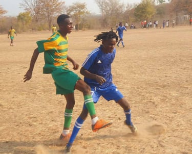 Soccer players in action on dusty field 