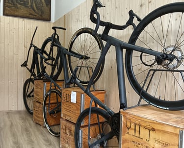 three carbon bikes are parked in a room with wooden crates