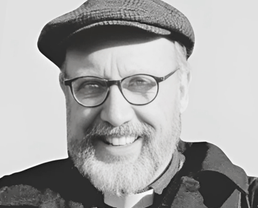 a picture of Rev. Mark Davidson wearing a flat cap and smiling at the camera