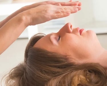 Practicing Reiki by hovering hands over a woman's face