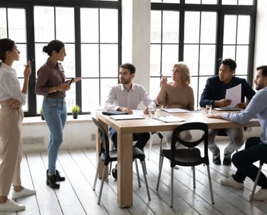A group of people discussing work at a table.