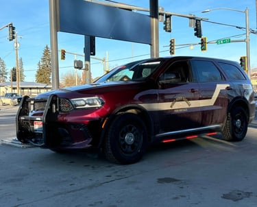 A maroon West Bend-Greeley Fire District chief vehicle, a Dodge Durango with a push bar, parked at a street intersection.