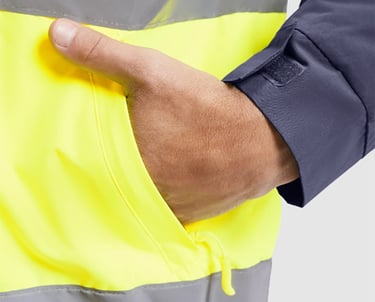 Imagen de una mano en el bolsillo de una prenda de alta visibilidad.