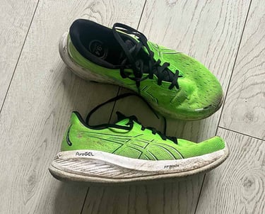 a pair of green Asics running shoes with black laces