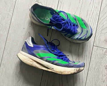 a pair of blue adidas running shoes with green stripes