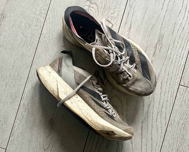 a pair of white adidas running shoes with black stripes