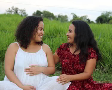 Mother and daughter sitting on a field