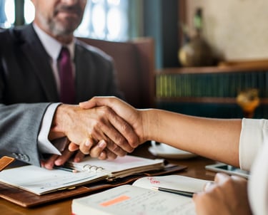 a man and woman shaking hands in a meeting