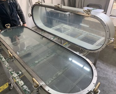 Oblong stainless ship windows in workshop
